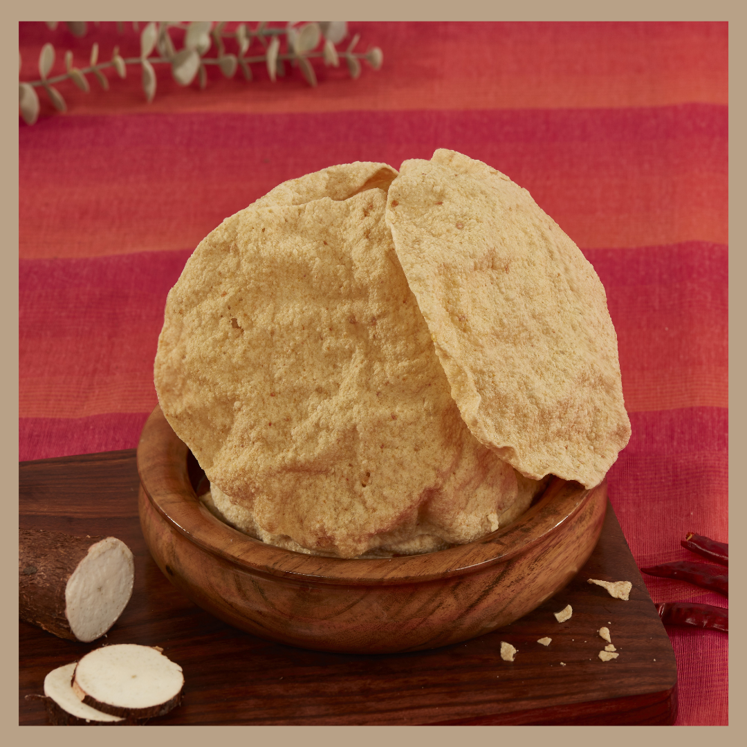 Buy tapioca appalam online from Malu's wooden bowl filled with crispy round tapioca appalams on red cloth