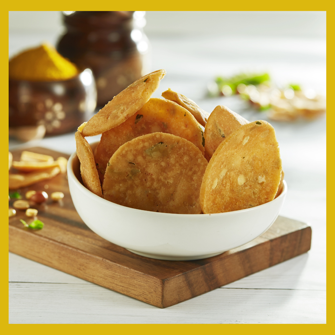Malu's crispy Thattai 180g served in a white bowl on a wooden board with spices in the background