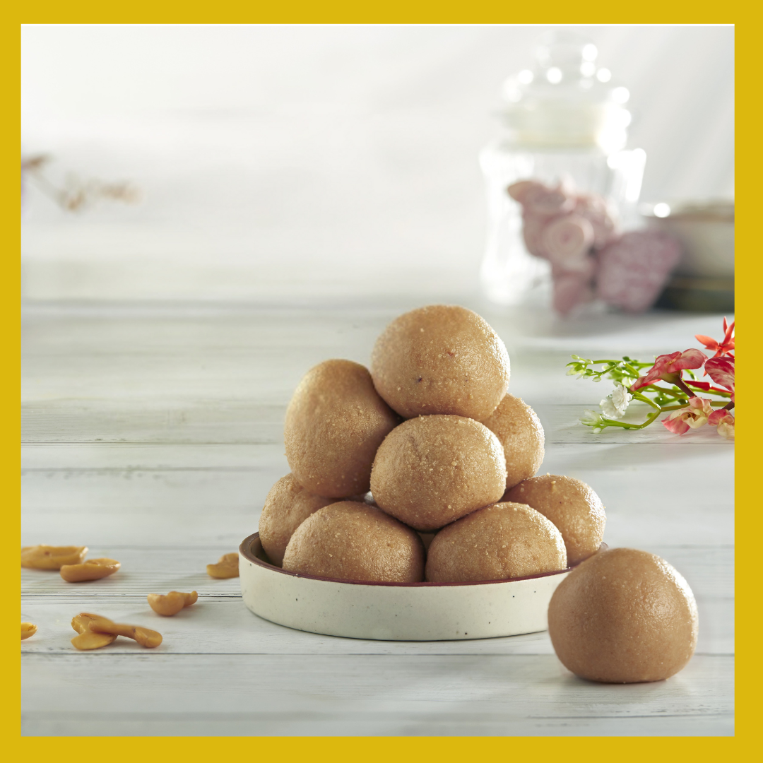Traditional Thanjavur Poori Ladoo stacked on a white plate with a blurred background and floral decoration